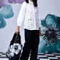 Stylera model wearing women's casual chic white shirt with lace front balloon sleeves black pants and floral tote