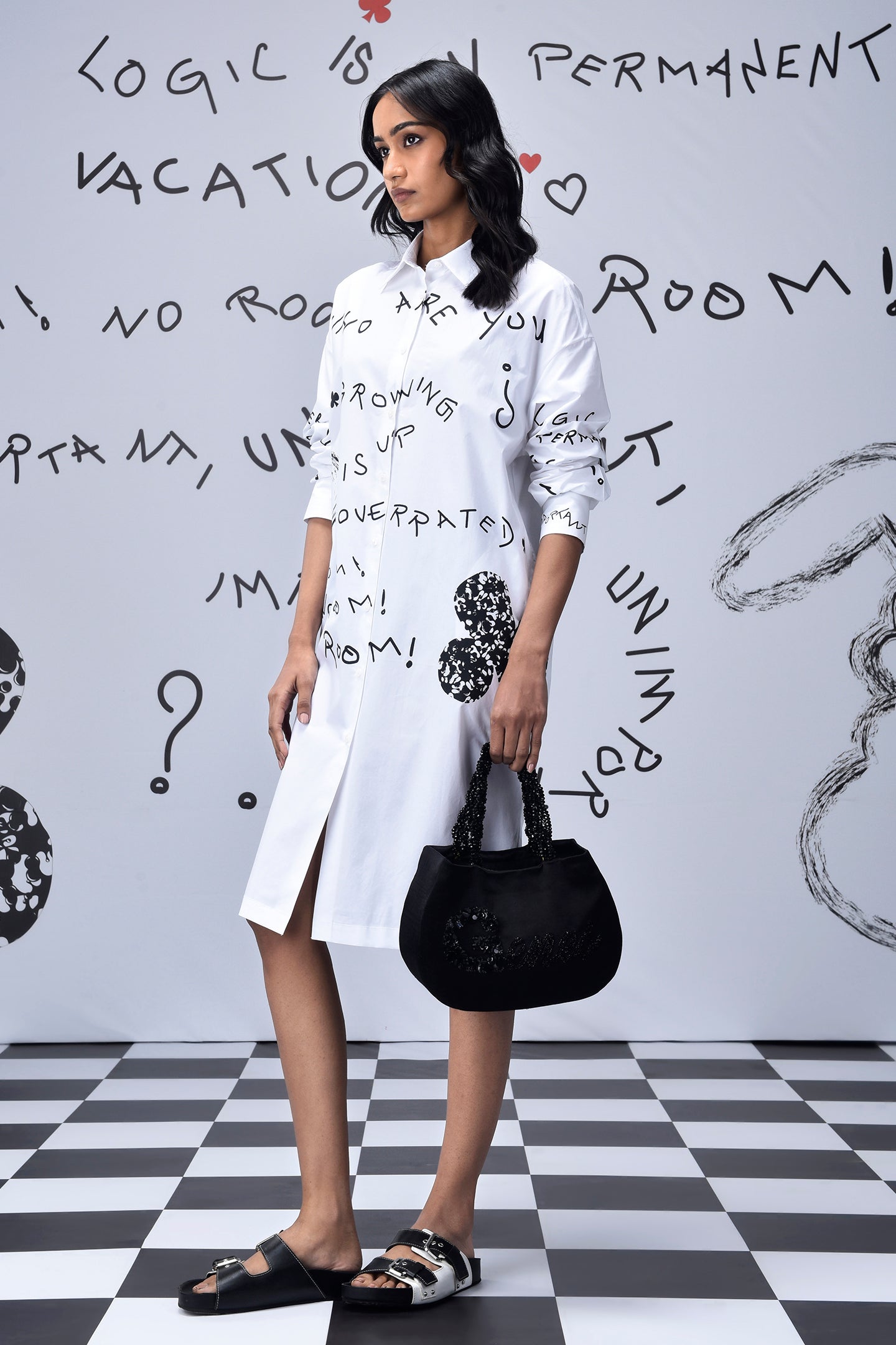 Stylera model wearing white knee length women’s casual shirt dress with print black bag