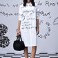 Model wearing Stylera women’s casual shirt dress with print white knee length shirt dress with black script