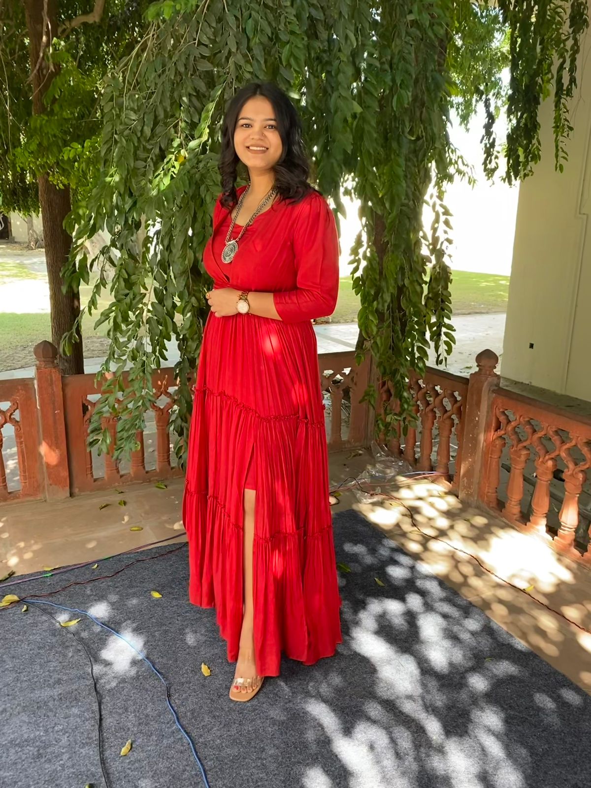 women's elegant long dress in red with tiered design and a side slit for stylish occasions