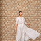 Model wearing a women's elegant long dress with tiered design and flowing fabric, perfect for formal occasions