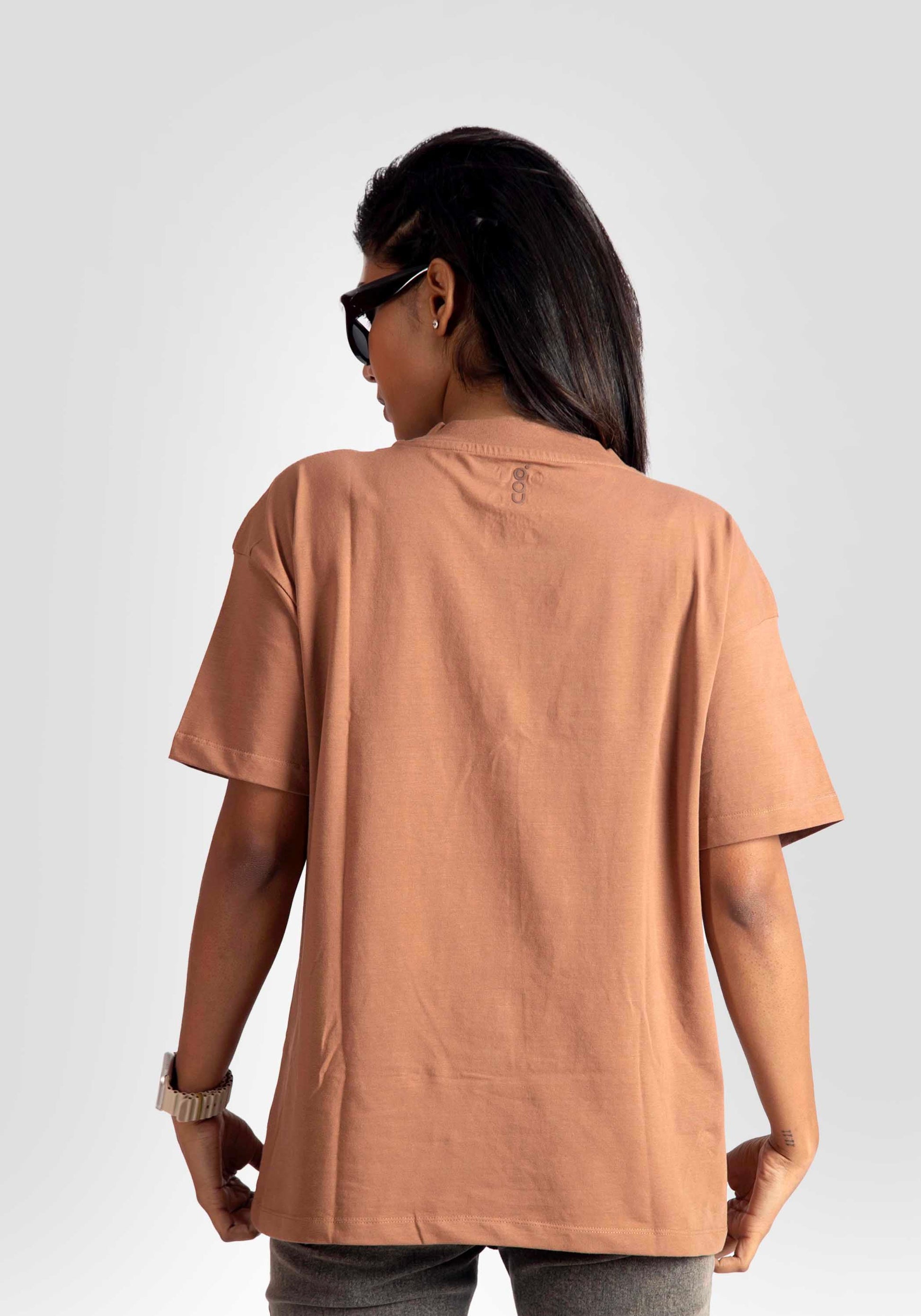 Back view of womens graphic oversized mocha tee by Stylera worn with sunglasses and watch