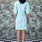 Back view of model wearing mint puff sleeve women's ikkat check casual dress knee length with lace up sandals on check floor