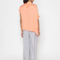 Stylera women's peach blouse with short sleeves and relaxed fit styled with gray pants