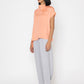Stylera women's peach blouse with short sleeves and high neckline paired with light gray pants