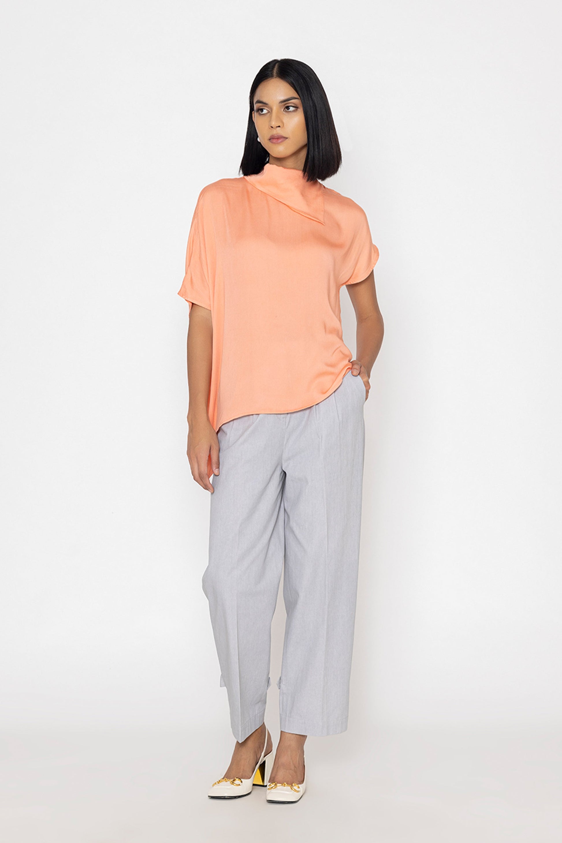 Stylera women's peach blouse with short sleeves and draped neckline styled with gray pants