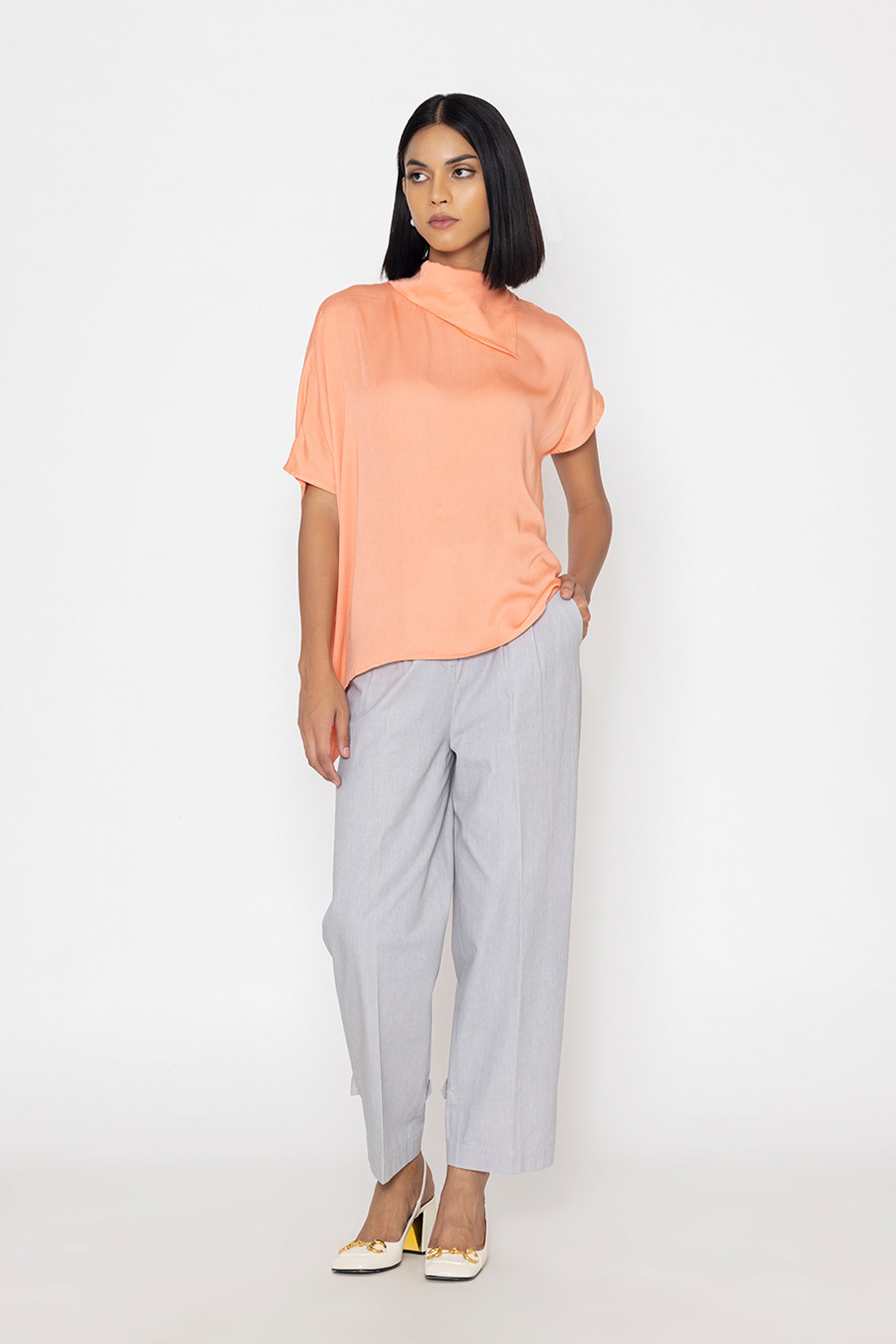 Stylera women's peach blouse with short sleeves and draped neckline styled with gray pants