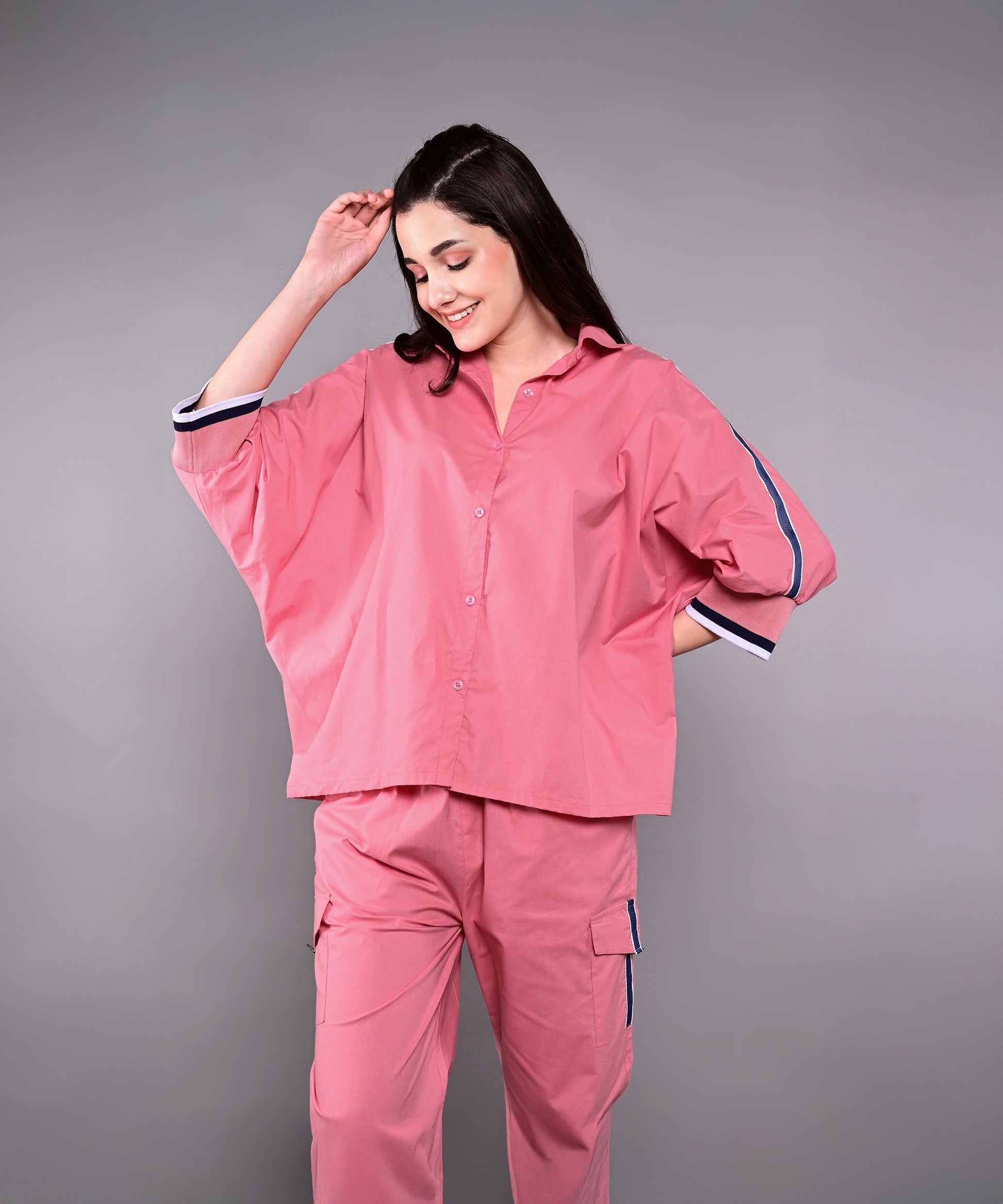 Stylish women's pink lounge set featuring a relaxed top and matching pants for comfort