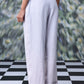 Back view of women's regular fit linen pants by Stylera in light fabric on a model