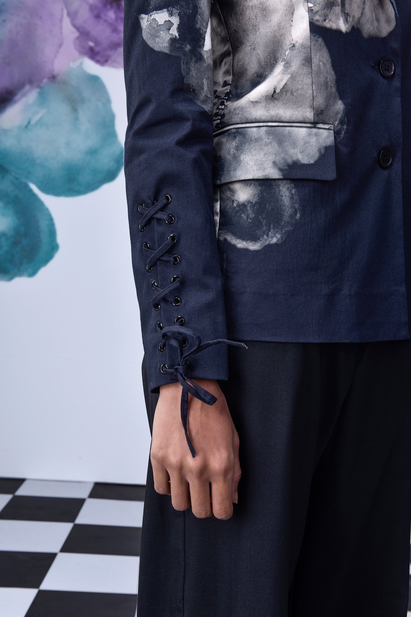 Close-up of Stylera women's statement blazer for work with lace-up sleeve detail in navy blue
