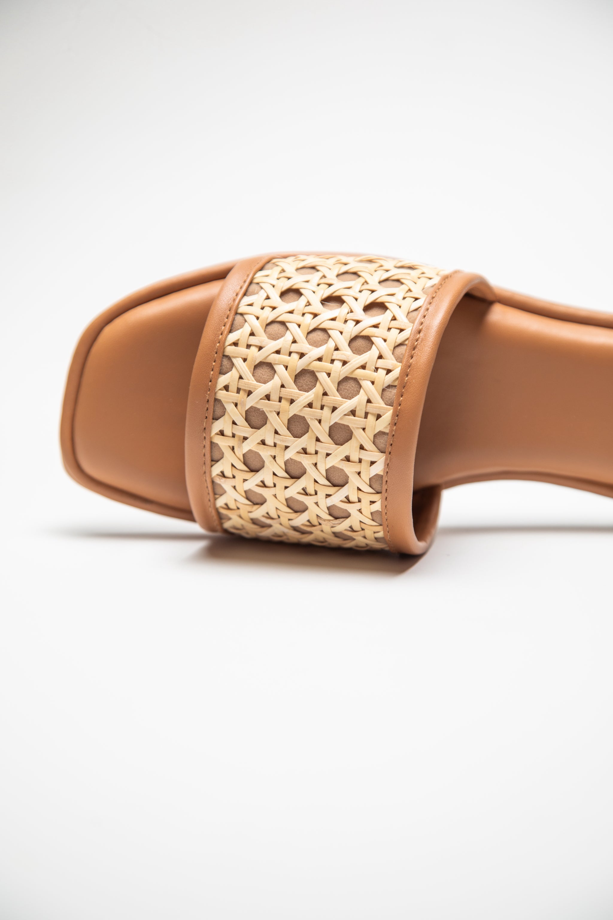 Close-up of Stylera women's summer flat sandals with woven beige strap and tan sole