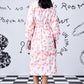 Back view of model wearing Stylera's women's trendy peach dress with belt long sleeves and heart print