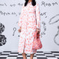 Stylera model wearing women's trendy peach dress midi with white sneakers and pink bag