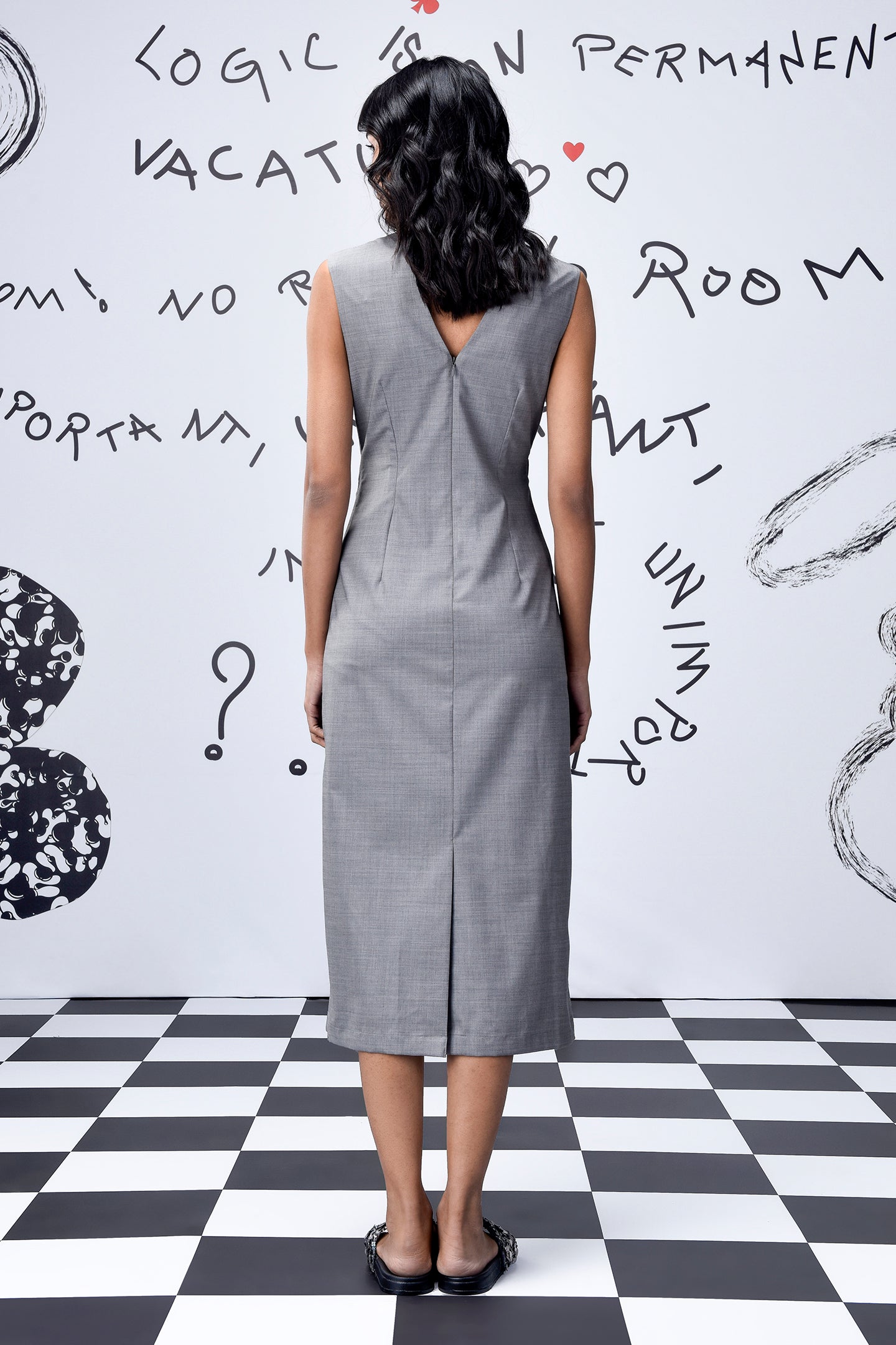 Back view of Stylera grey sleeveless sheath dress with back V and slit on model women's trendy wool dresses