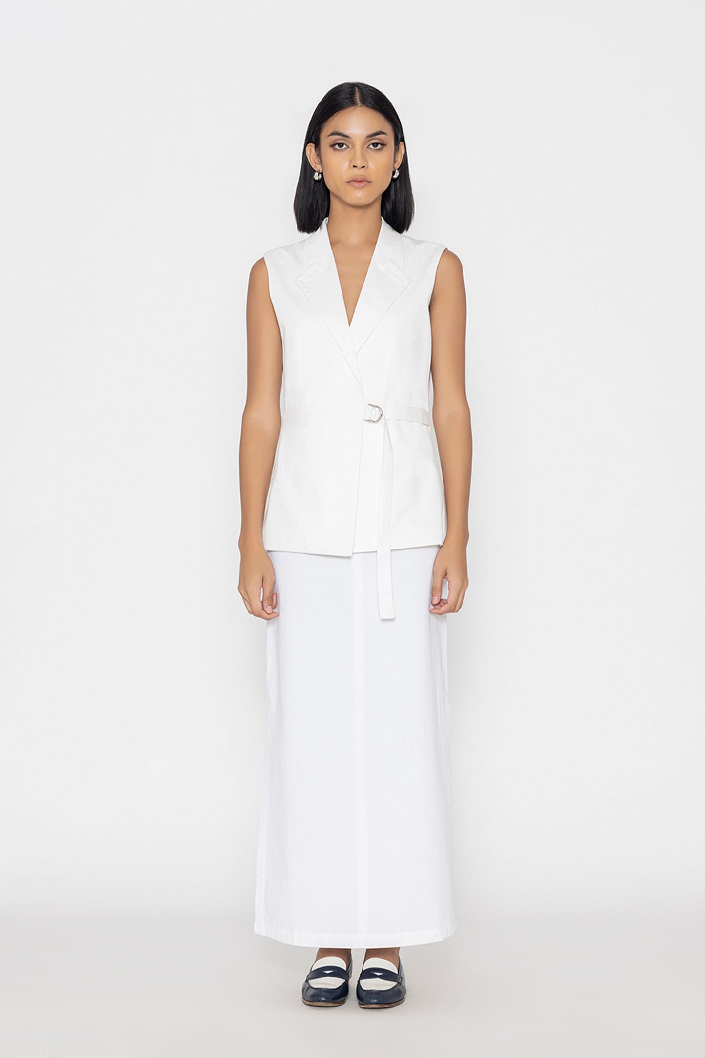 Stylera women's white sleeveless vest with belt worn with a long white skirt