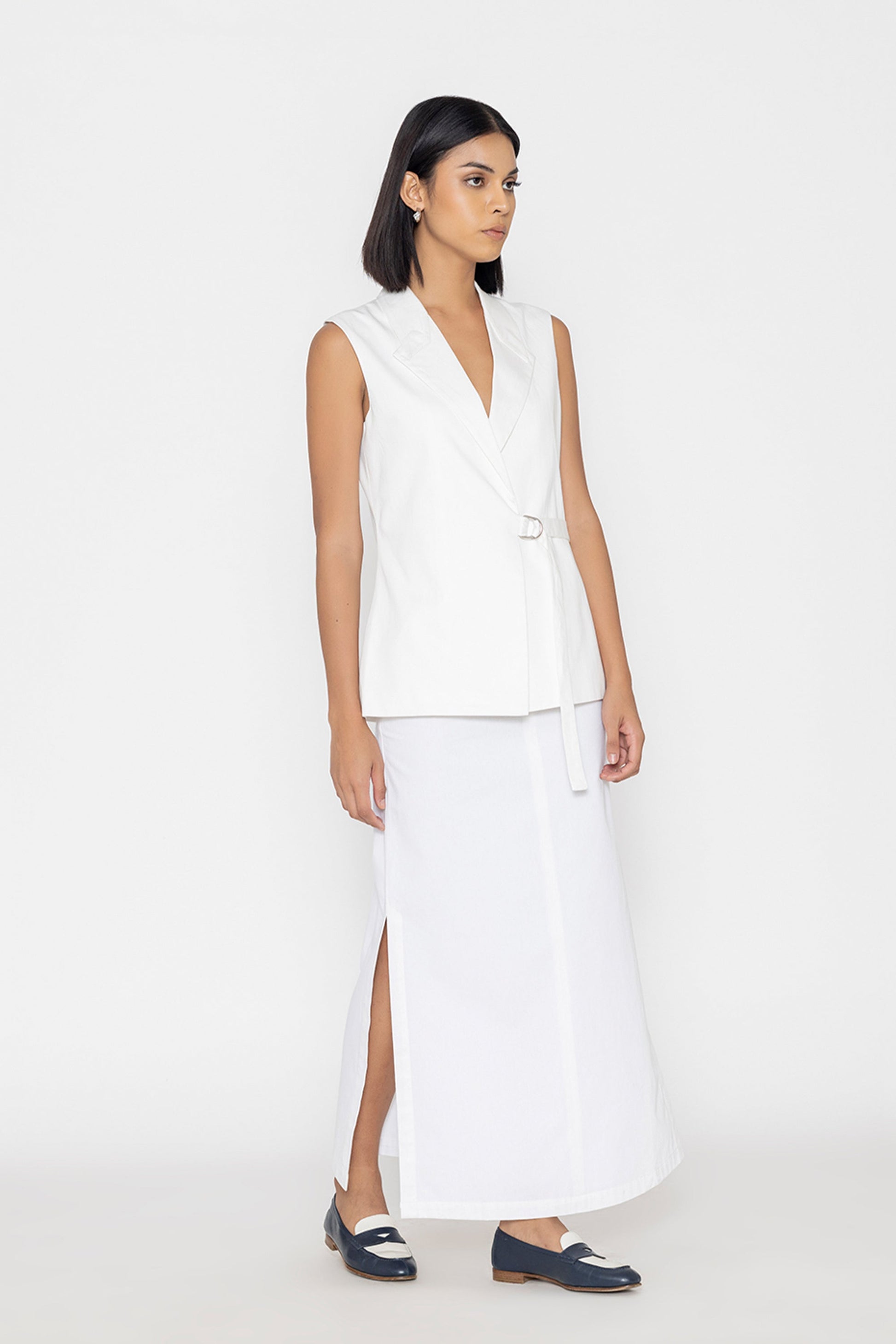 Stylera women's white sleeveless vest with side buckle and V-neck styled with long white skirt