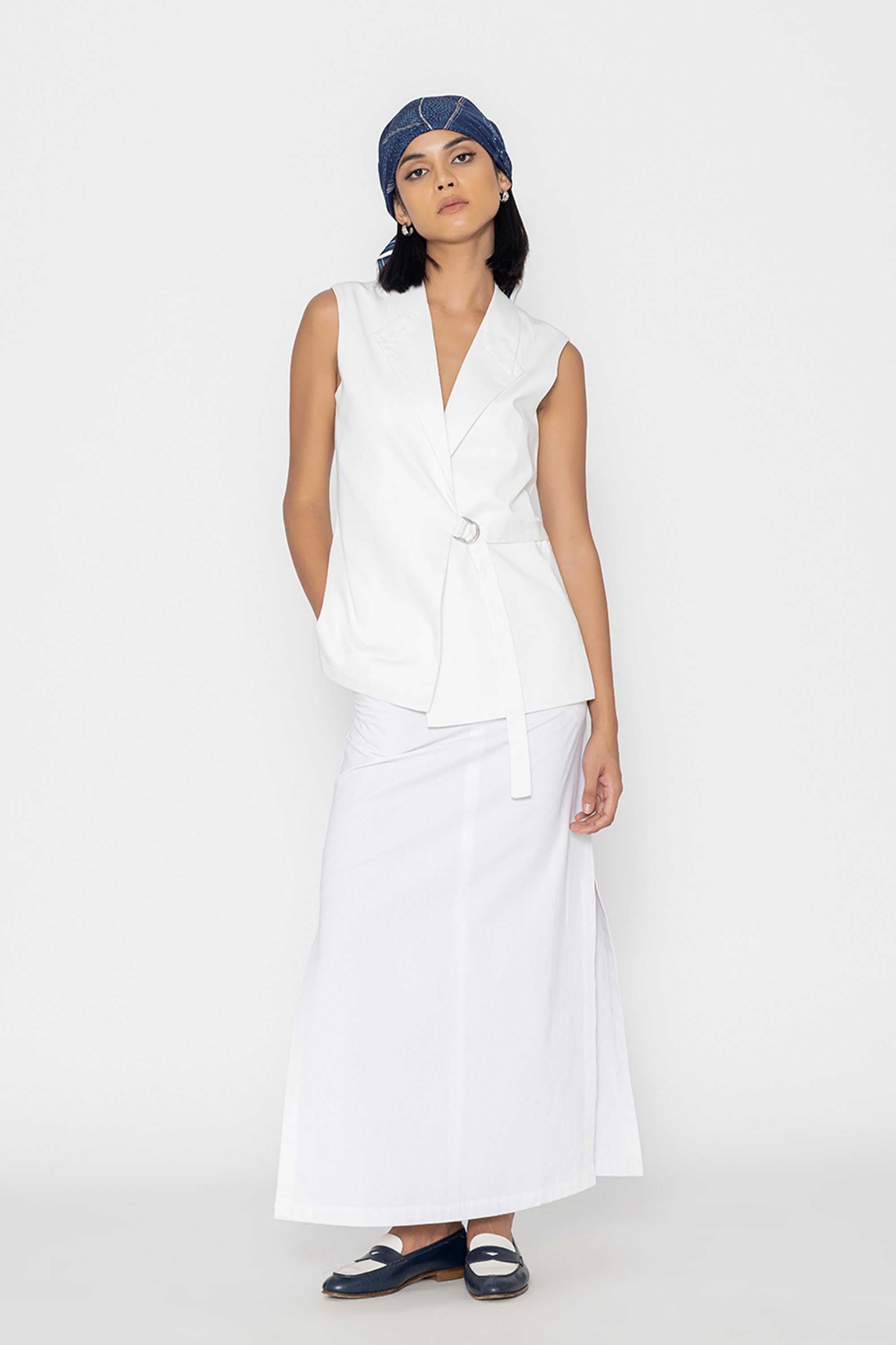 Stylera women's white sleeveless vest with wrap design worn with long white skirt and blue bandana