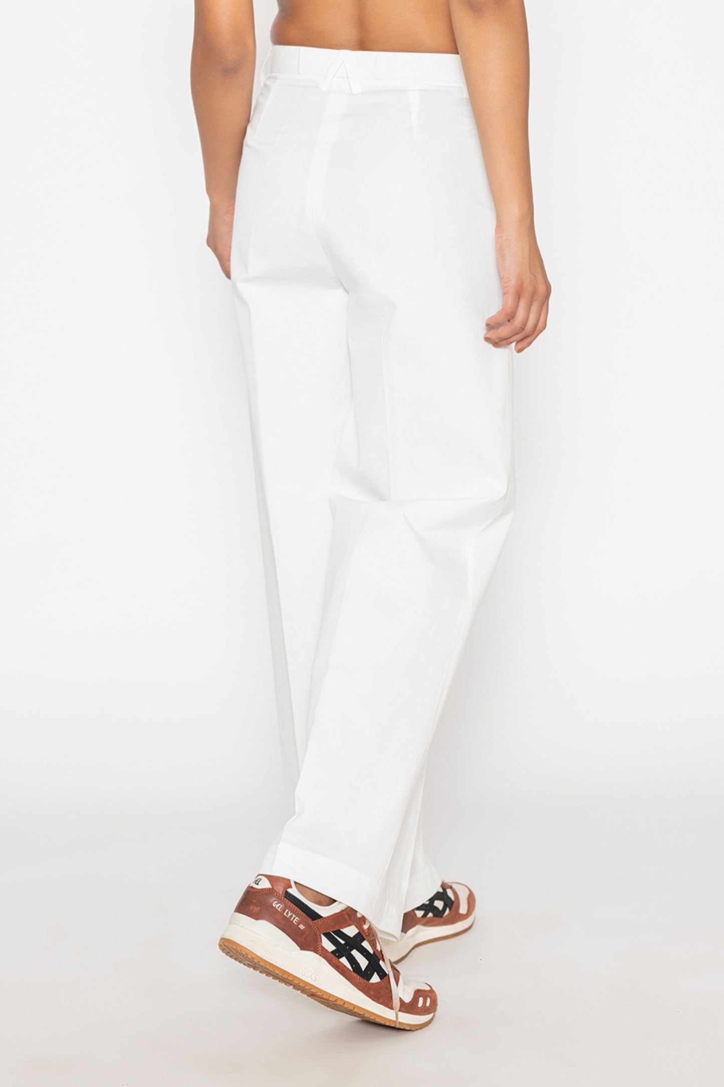 Stylera women's white wide leg trousers shown from the back with casual sneakers