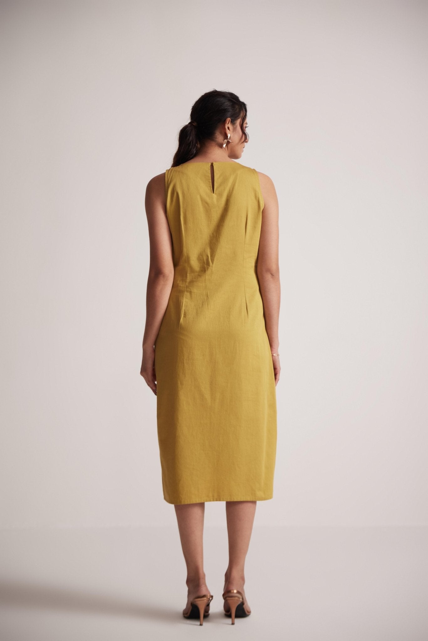 Stylera yellow draped midi dress shown from back on model with sleeveless design