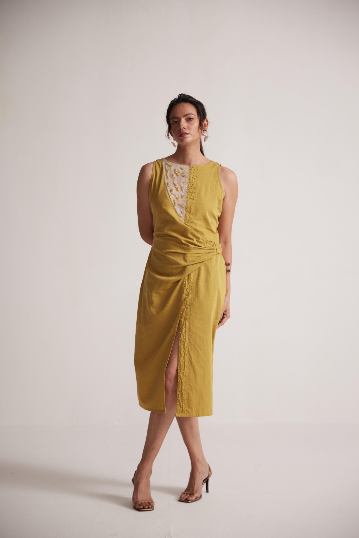 Stylera yellow draped midi dress with sleeveless design and front slit worn by model