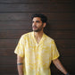 Stylish man wearing a yellow oversize shirt for men with a modern tropical print, perfect for casual outings