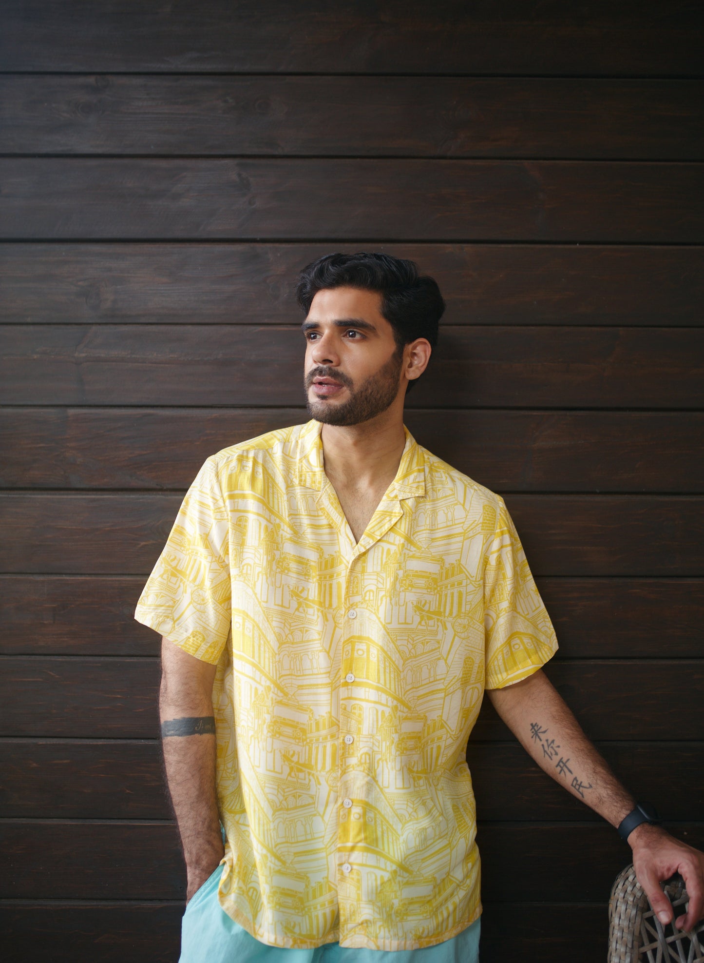 Stylish man wearing a yellow oversize shirt for men with a modern tropical print, perfect for casual outings