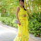 Stylera yellow saree with floral print, gracefully worn in a lush garden setting