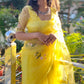 Model wearing a yellow sunflower saree with floral embroidery and elegant accessories