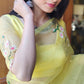 Elegant yellow sunflower saree with floral embroidery, styled with traditional accessories